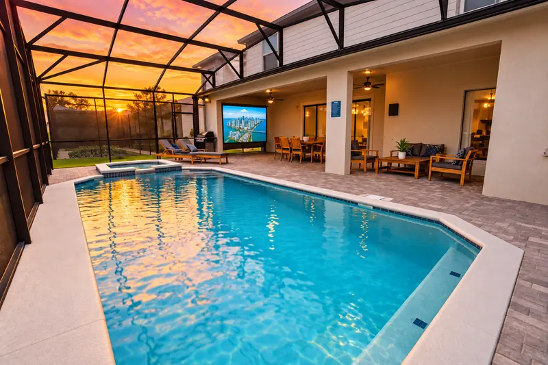Screened pool deck with outdoor living area and screen at sunset