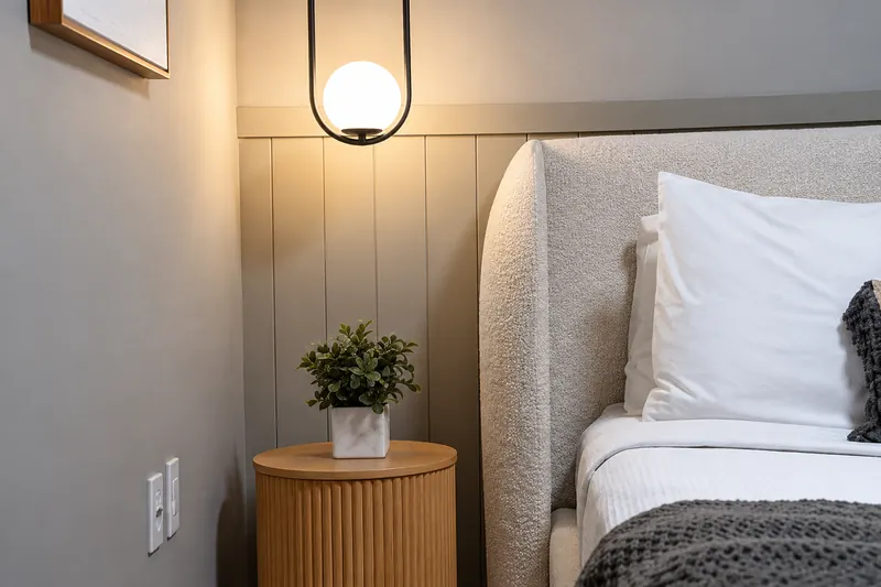 Globe pendant light above a fluted wood side table